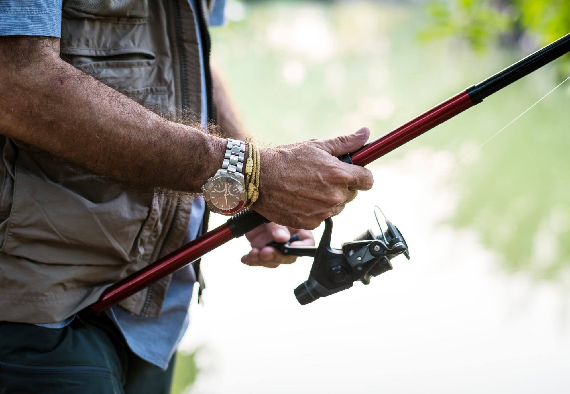 An angler holding a spinning rod and reel by the water, ready for a day of fishing in Panama